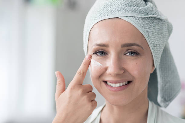istock Beautiful woman applying cream on her face after bath 1383097792
