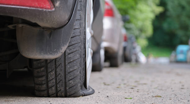 istock Car with punctured flat tire parked on roadside 1383099756