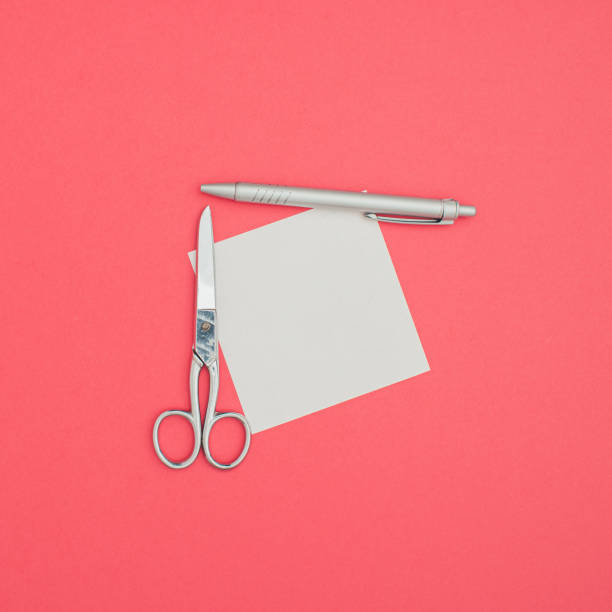 istock Office Square leaflet mock up blank template design idea. Office scissors and ballpoint pen mockup against pastel pink background. Copy space templates designs for message layout. 1383100050