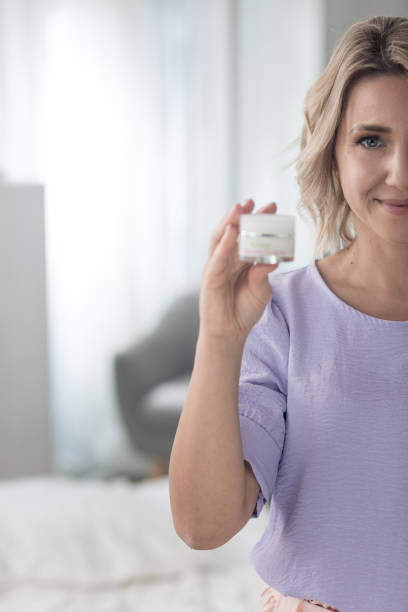 istock Woman holding jar of moisturizer 1383101577