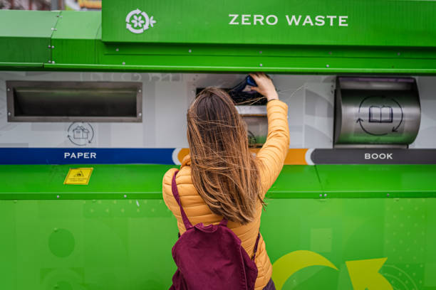 Beautiful Woman separating glass and pet bottle for waste management stock photo
