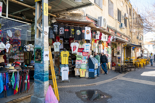 TEL AVIV, ISRAIL - January 25, 2022: Israelis shop at the Carmel Market Shuk HaCarmel in Tel Aviv, Israel. This is a very popular market in Tel Aviv where clothes and fruits and vegetables are sold.