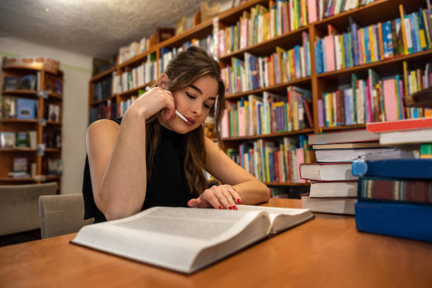 istock student girl reading book at university library 1383108225