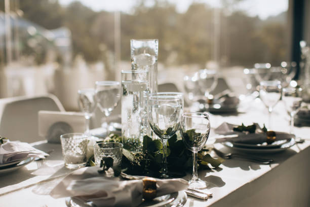 istock Luxury table setting for dining in white colors with flowers and candles in restaurant 1383108905