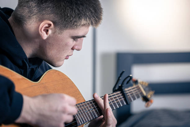 istock A young man plays the acoustic guitar. 1383109890