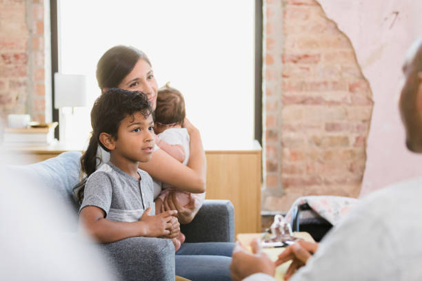 istock Mother holds baby while big brother talks to principal 1383109939