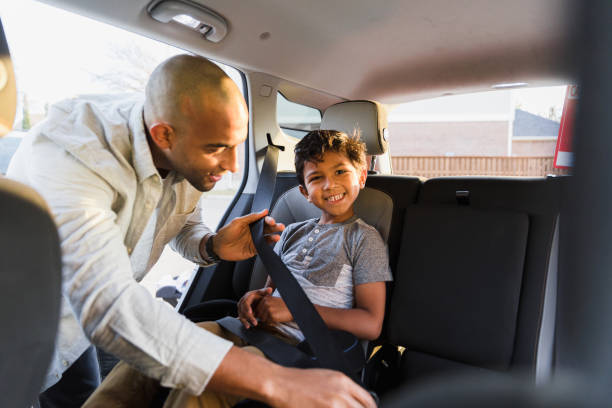 istock While dad buckles son in car, boy looks at camera 1383109961