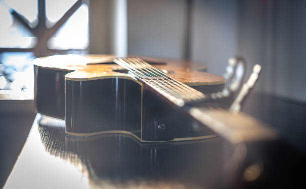 primer plano de una guitarra acústica sobre un fondo borroso. - musical instrument string music dark old fashioned fotografías e imágenes de stock