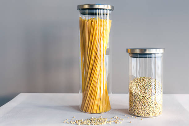 Spaghetti and cereals in glass jars, isolated, concept of storage of cereals and pasta in the kitchen.
