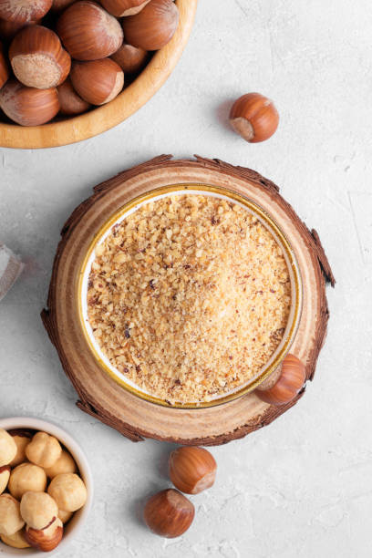 istock Raw Organic Ground Hazelnut Flour in a Bowl with whole nuts on grey stone background. Alternative nut flour 1383111693