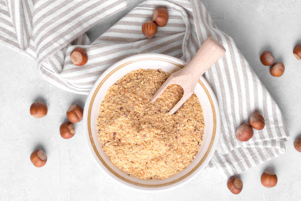 istock Raw Organic Ground Hazelnut Flour in a Bowl with whole nuts on grey stone background. Alternative nut flour 1383111705
