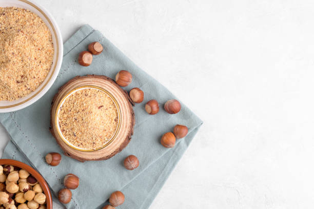 istock Raw Organic Ground Hazelnut Flour in a Bowl with whole nuts on grey stone background. Alternative nut flour 1383111709