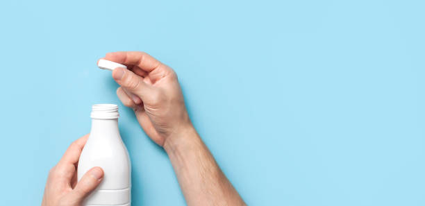 istock White plastic bottle containers for dairy products in male hands on blue background top view flat lay. Plastic Kefir Yogurt Milk Bottle. Packaging template mockup. Layout for your design 1383113656