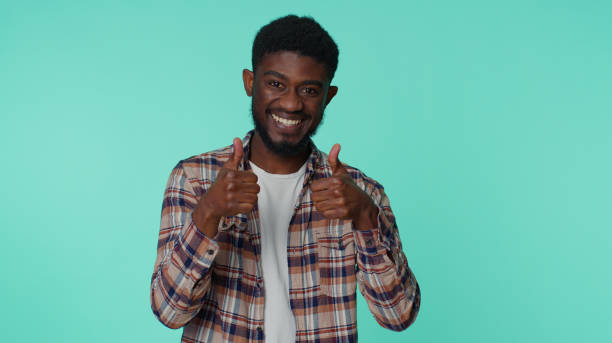 istock Bearded man raises thumbs up agrees or gives positive reply recommends advertisement likes good 1383116086