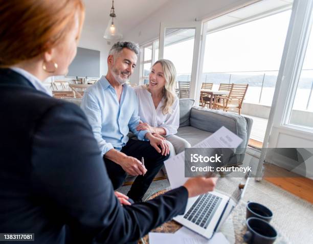 Happy Mature Couple Meeting Investments And Financial Advisor At Home Stock Photo - Download Image Now