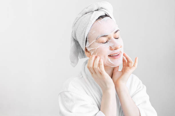istock Young woman with sheet mask on her face, spa procedure. 1383117152