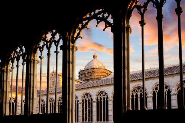 kopuła katedry duomo pisa jest widoczna pod kolorowym zachodem słońca z wnętrza kamiennych łukowatych okien camposanto monumentale w toskańskim mieście piza we włoszech. - camposanto monumentale zdjęcia i obrazy z banku zdjęć