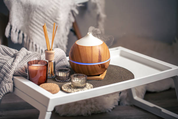 A cozy composition with an aroma diffuser and candles in a home interior. stock photo