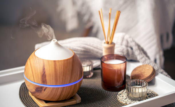 una composizione accogliente con un diffusore di aromi e candele in un interno domestico. - aromaterapia foto e immagini stock