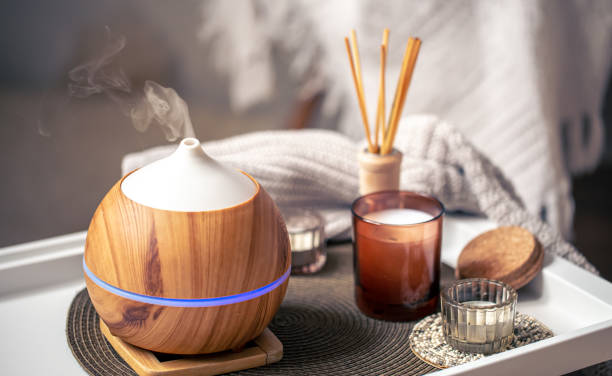 A cozy composition with an aroma diffuser and candles in a home interior. stock photo