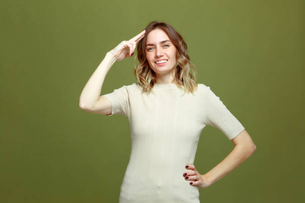 istock Friendly confident young girl saluting with respect, doing honour gesture, smiling on green studio background 1383118510