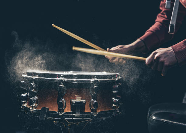 The drummer's hands hold drumsticks and play the snare drum. A man plays a snare drum with sticks, a drummer plays a percussion instrument, close up. drummer hands stock pictures, royalty-free photos & images