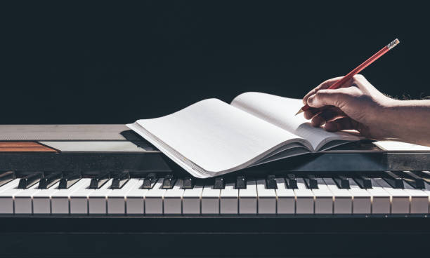 istock A man plays the piano and writes in a notebook in the dark. 1383119665