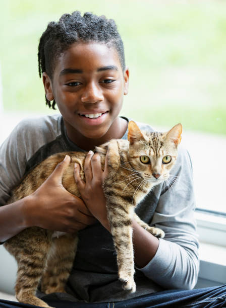 istock Happy African-American boy holding pet cat 1383123444