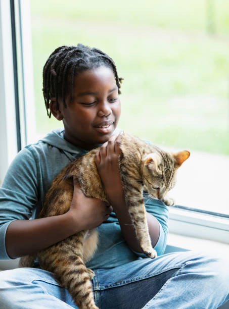 istock Happy African-American boy holding pet cat 1383123447