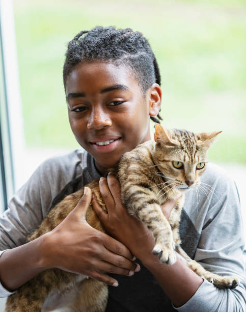 istock Happy African-American boy holding pet cat 1383123464