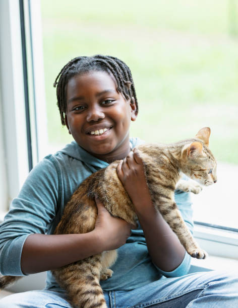 istock Happy African-American boy holding pet cat 1383123470