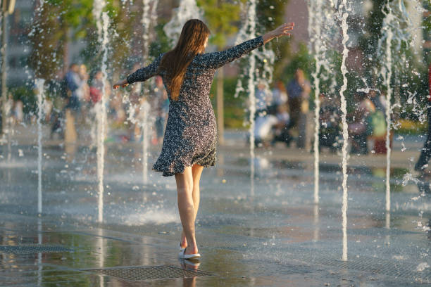 Young woman playing with water of fountain in the Moscow public park stock photo