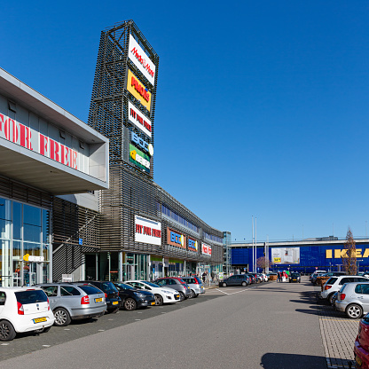 Hengelo, Twente, Overijssel, Netherlands, february 23rd 2022, small group of people shopping and cars parked on the parking lot at retail park \