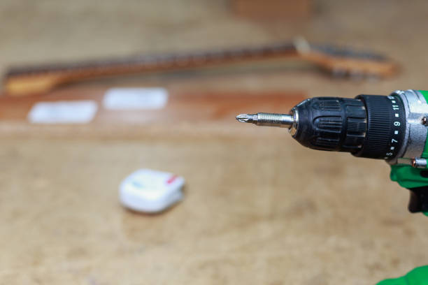 istock Element of a screwdriver with a bit for screws on a blurred backdrop of a workshop. Background with copy space 1383131652
