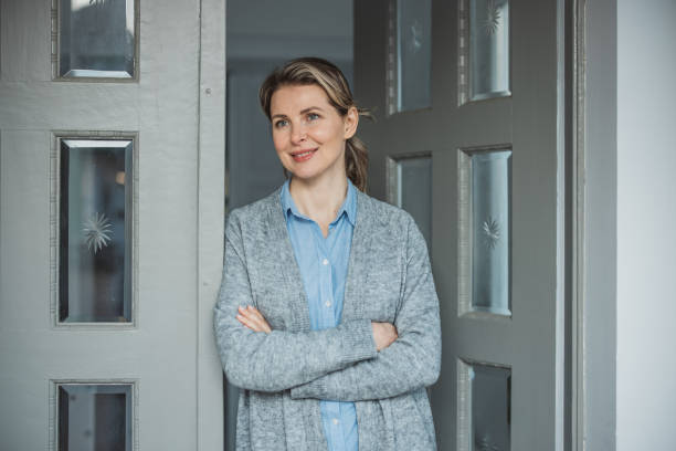 istock Woman standing at hose front door 1383133153