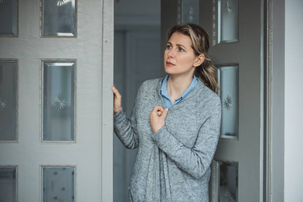 istock Woman standing at hose front door 1383133168