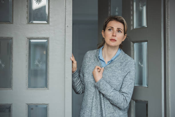 istock Woman standing at hose front door 1383133176