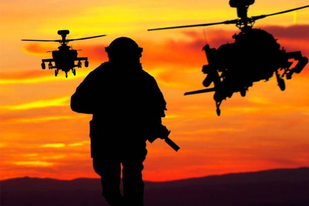 Silhouette of the infantry soldier, marine corps fighter, a navy special operations team member in full tactical ammunition running with a weapon in hands during airborne operation with helicopters support. High-quality photo silueta de soldado de infantería, combatiente del cuerpo de marines, miembro del equipo de operaciones especiales de la marina en munición táctica completa corriendo con arma en las manos durante la operación aerotransportada con apoyo de helicópteros