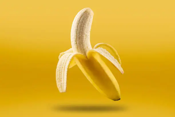 Photo of Ripe bananas isolated on yellow background.