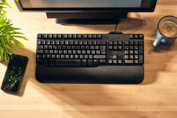 istock brown wooden desk with desktop computer from above 1383136812