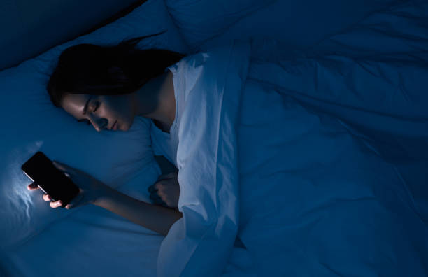 istock Woman sleeping with smartphone in bed 1383176527