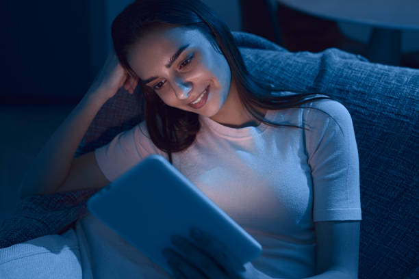 istock Woman reading e book in evening 1383177060