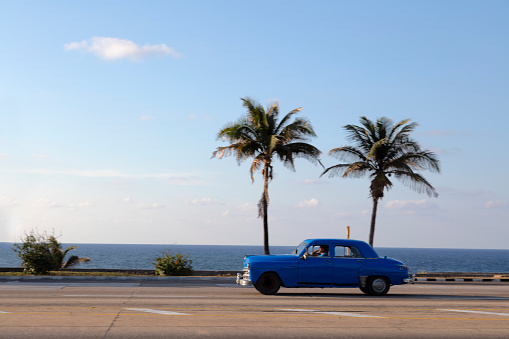 Vintage American car driving along Gulf of Mexico coast towards Havana, Cuba