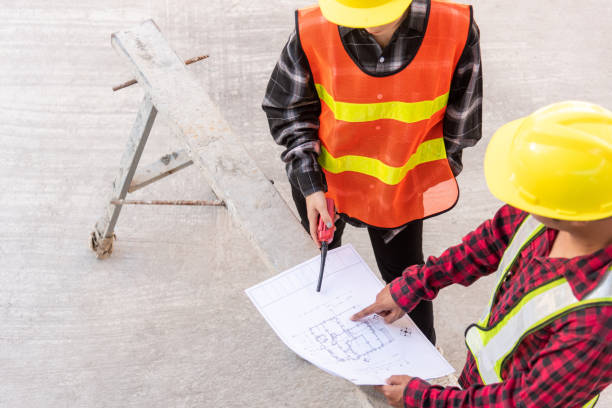 istock Architect and client discussing help create plan with blueprint of the building at construction site floor. Asian engineer foreman worker man and woman meeting and planning construction work, top view 1383200589