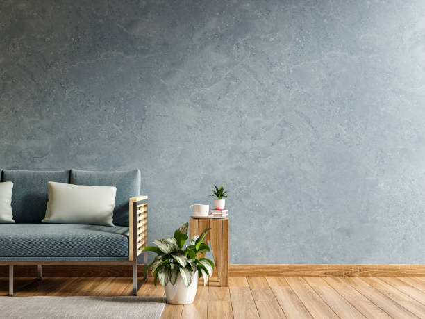 istock Empty living room with blue sofa and table on empty blue concrete wall background. 1383220407