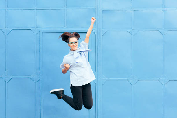 istock Excited Woman Jumping with Joy on a Blue Background 1383221027