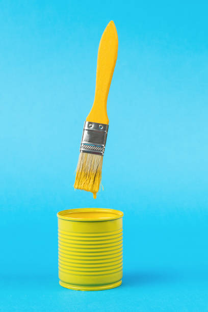 istock A brush with dripping paint over a jar on a bright blue background. Trending colors. 1383228955