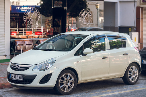 Side, Turkey – February 16 2022:  white Opel Corsa is parked  on the street on a warm day
