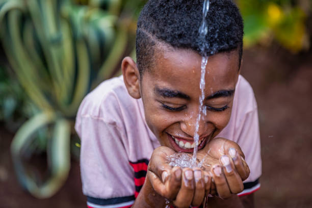 African young boy drinking fresh water, East Africa