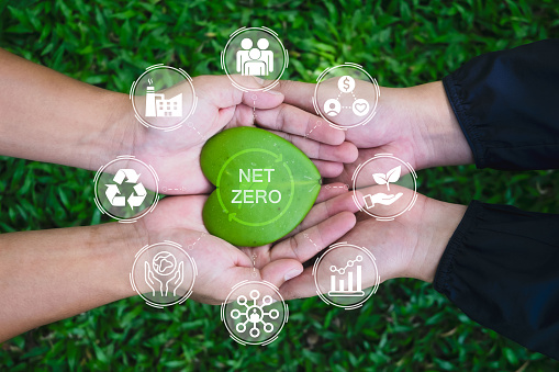 Net zero and carbon neutral concept. Hands adult Teamwork harmony Holding heart leaf on hands with green net zero icon and green icon. Net zero greenhouse gas emissions target. Climate neutral long term strategy.